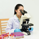 A medical laboratory professional for IVF in Vietnam conducting diagnostic tests with a microscope and blood samples.