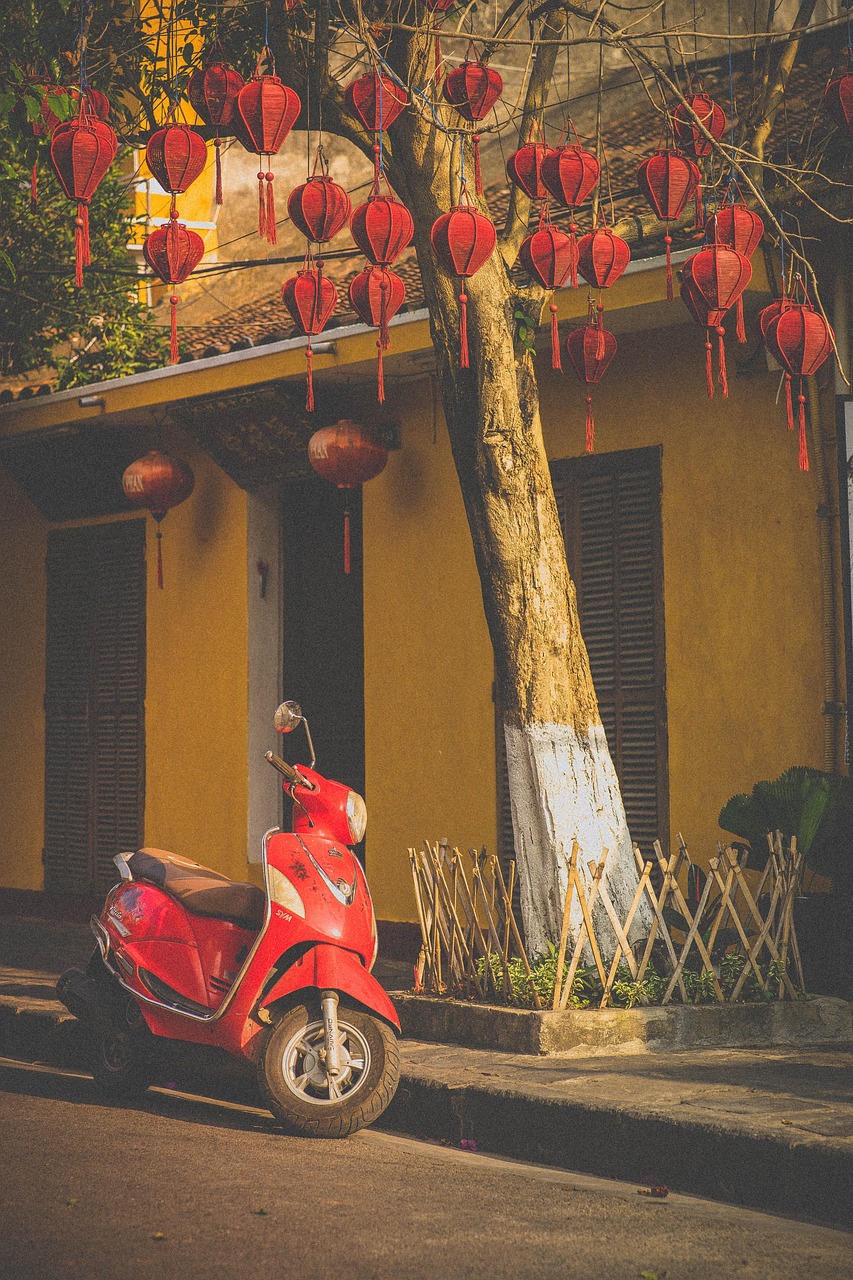 A classic red motorbike parked in front of traditional red lanterns, capturing the cultural charm of Vietnam for luxury medical travelers getting surgery abroad solo.