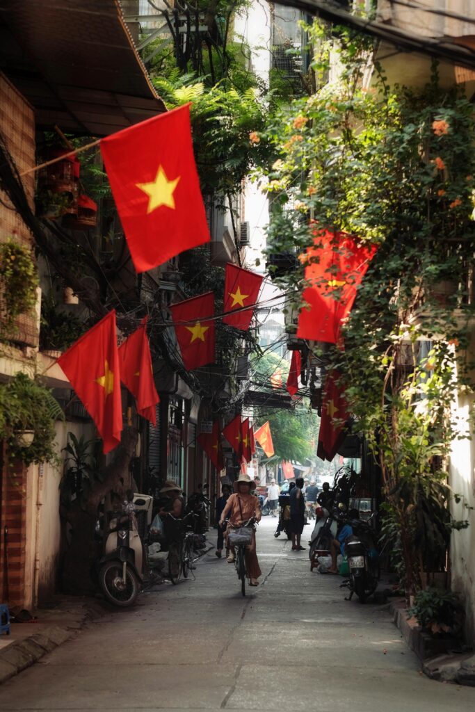 Bustling street in Hanoi adorned with Vietnamese flags celebrating National Day. Vietnam vs Thailand for Cosmetic Surgery