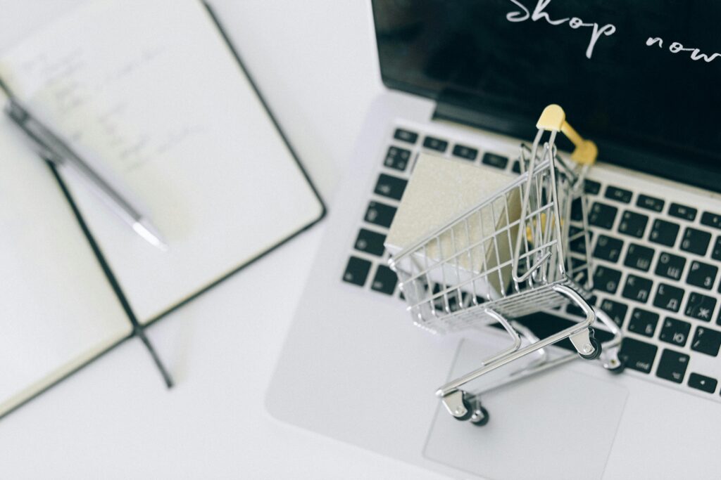 Creative depiction of online shopping with a miniature cart on a laptop keyboard, looking for cosmetic surgeons in Vietnam