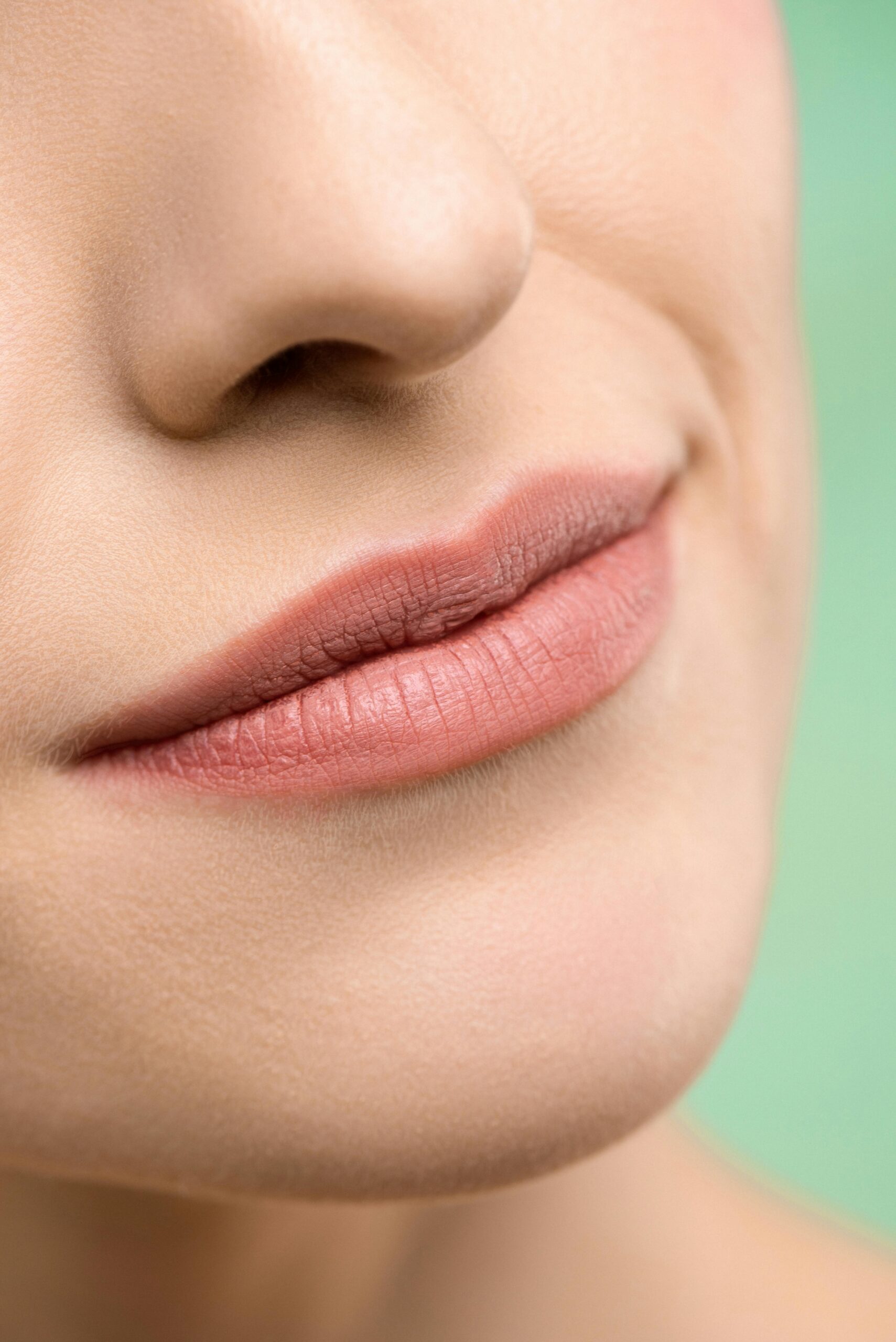 A close-up image of a woman's lips with natural makeup highlighting the soft lip texture.